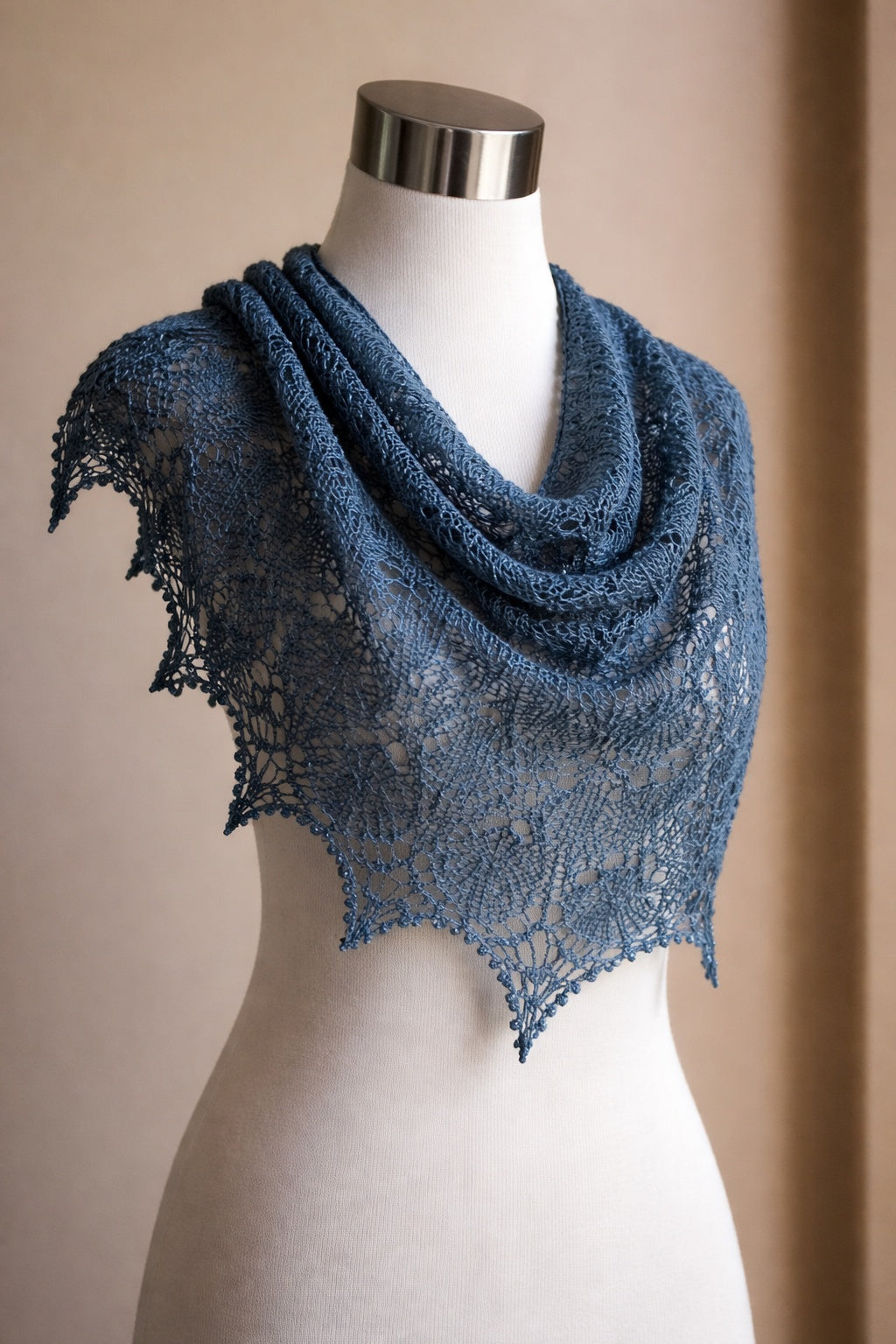 Blue lace shawl on a mannequin against a beige background